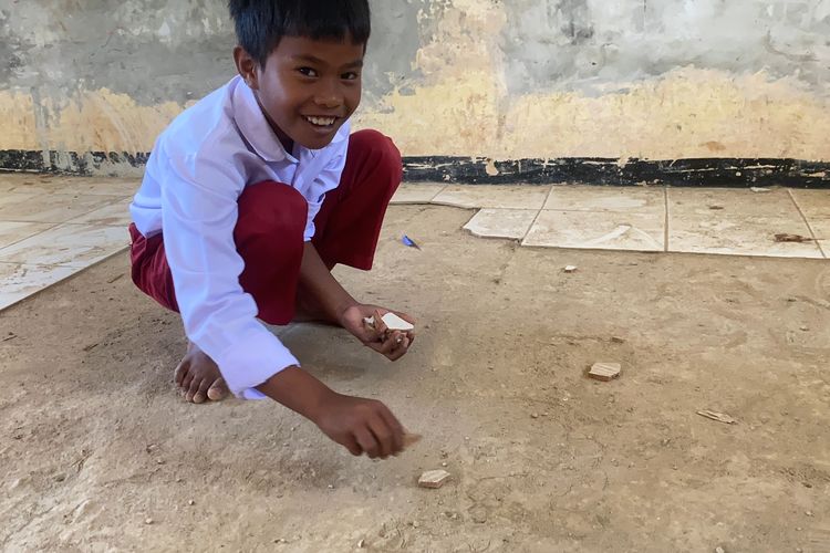 Salah seorang siswa kelas V SDN Ciaripin, berinisiatif mengumpulkan pecahan keramik karena khawatir terinjak orang lain. Rabu (21/8/2024).