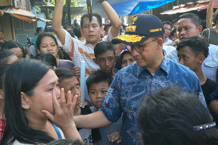 Seorang perempuan yang rumahnya terbakar mengadu kepada Gubernur DKI Jakarta Anies Baswedan saat meninjau permukiman yang terbakar itu di Jalan Keutamaan Dalam, Kelurahan Krukut, Tamansari, Jakarta Barat, Sabtu (27/1/2018) sore.