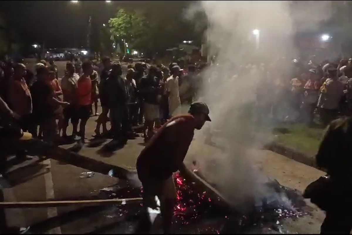 KELUARGA BLOKADE JALAN - Warga membersihkan puing-puing pemalangan