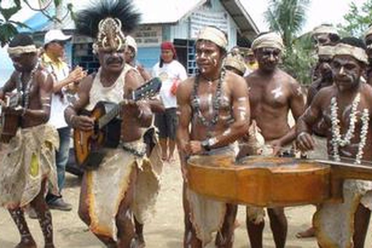 Para pria Desa Sawinggrai, Raja Ampat, menyanyikan lagu dan memainkan musik yang mengiringi tarian makakero.