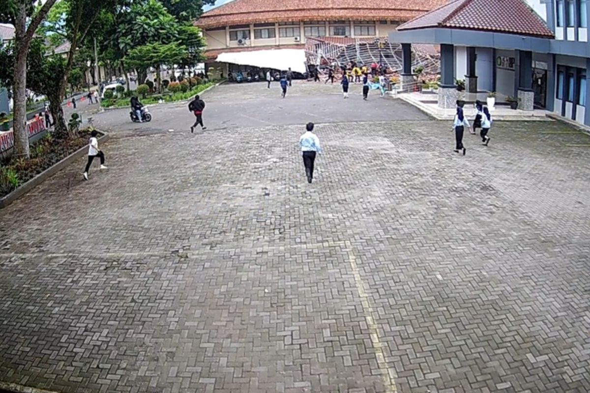 Para mahasiswa dan staf Unsil Tasikmalaya, Jawa Barat, berlarian saat menyelamatkan rekan-rekannya yang tertimpa atap gedung FKIP Unsil yang tiba-tiba ambruk di siang bolong pada Minggu (16/11/2025).