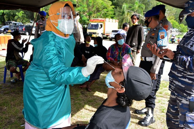 Petugas kesehatan melakukan tes swab antigen COVID-19 terhadap penumpang kapal yang baru tiba dari Pulau Sabang di Posko Pengetatan Pemberlakuan Pembatasan Kegiatan Masyarakat (PPKM) Mikro, Pelabuhan Penyeberangan Ulee Lheue, Banda Aceh, Aceh, Senin (12/7/2021). Operasi penyekatan yang berlangsung hingga tanggal 19 Juli 20021 di pintu masuk dan keluar pelabuhan Ulee Lheue Banda Aceh sebagai zona merah itu sebagai syarat penyeberangan sesuai aturan Pengetatan PPKM Mikro untuk mengantisipasi peningkatan kasus CID-19. ANTARA FOTO/Ampelsa/aww.