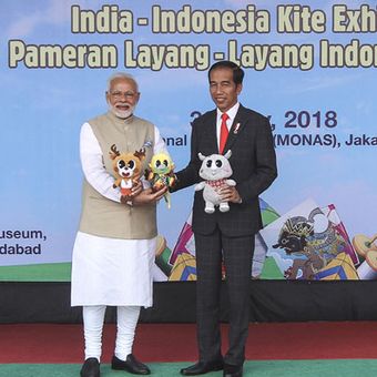 Presiden Joko Widodo (kanan) menyerahkan maskot Asian Games kepada Perdana Menteri (PM) India Narendra Modi (kiri) pada Pameran Layang-Layang Indonesia-India di kawasan Monas, Jakarta, Rabu (30/5/2018). Pada kunjungan resmi pertama PM India ke Indonesia Presiden Joko Widodo mengajak untuk bermain dan menghadiri pameran layang-layang yang merupakan permainan tradisional populer di Indonesia dan India.  