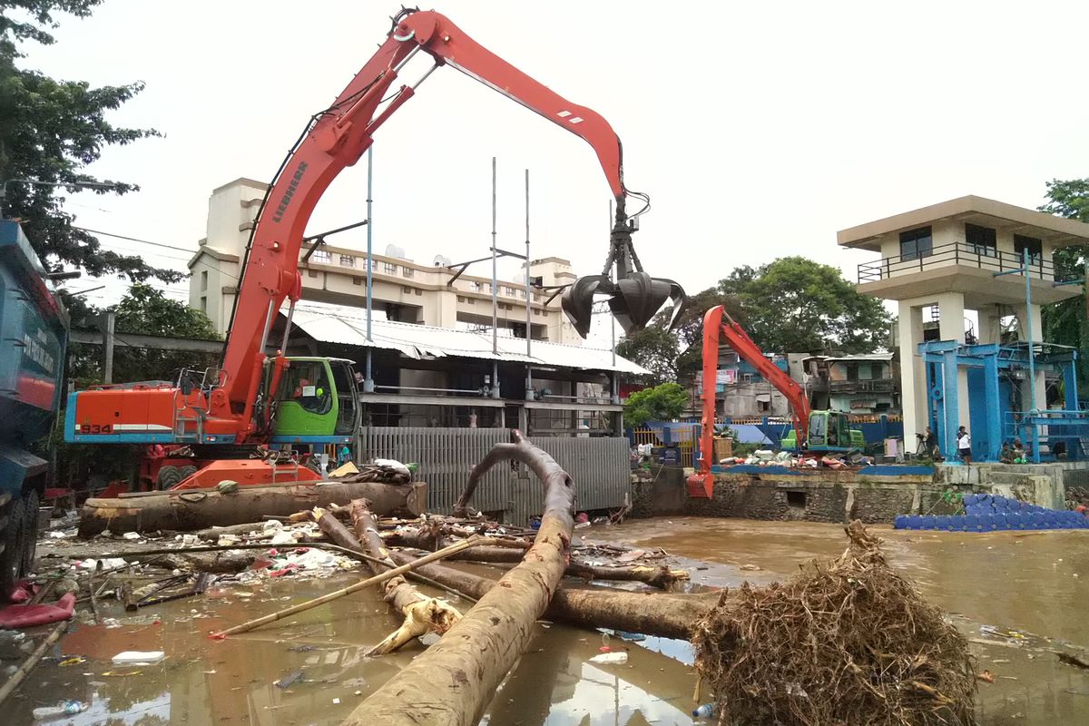 Salah satu petugas mengangkut sampah di Pintu Air Manggarai pada Kamis (2/1/2020)