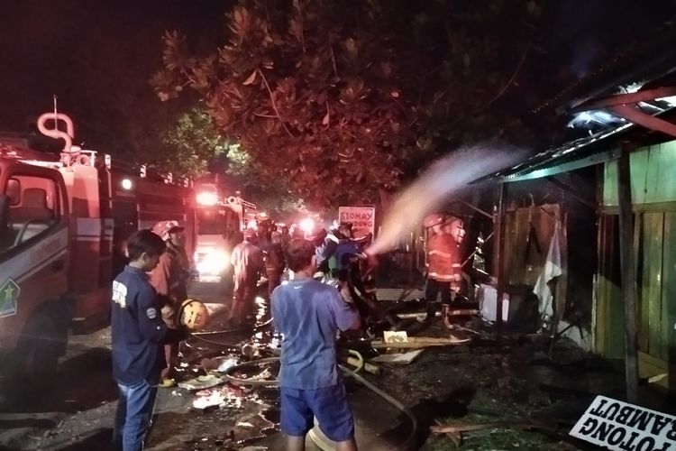 Petugas UPT Pemadam Kebakaran (PMK) Kota Malang berupaya memadamkan api di kios ikan hias milik Dewi Purnama Sari (35) yang berada di Jalan Raya Ki Ageng Gribig, RT 2 RW 1, Kelurahan Lesanpuro, Kota Malang pada Sabtu (7/1/2023) malam. 