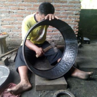 TEMPA--Salah satu karyawan Agung Kuncoro menempa lempengan untuk membentuk gong. 