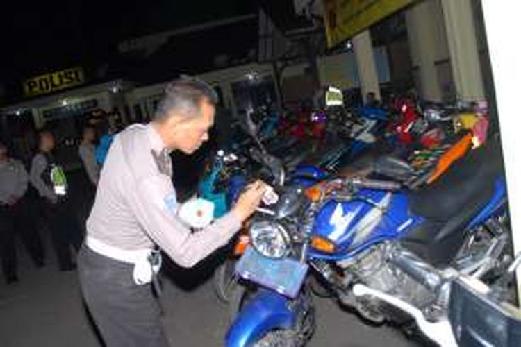 Petugas kepolisian memasang stiker pendataan di sepeda motor hasil Operasi Cipta Kondisi di Polres Sukabumi Kota, Sukabumi, Jawa Barat, Selasa (21/6/2016). 