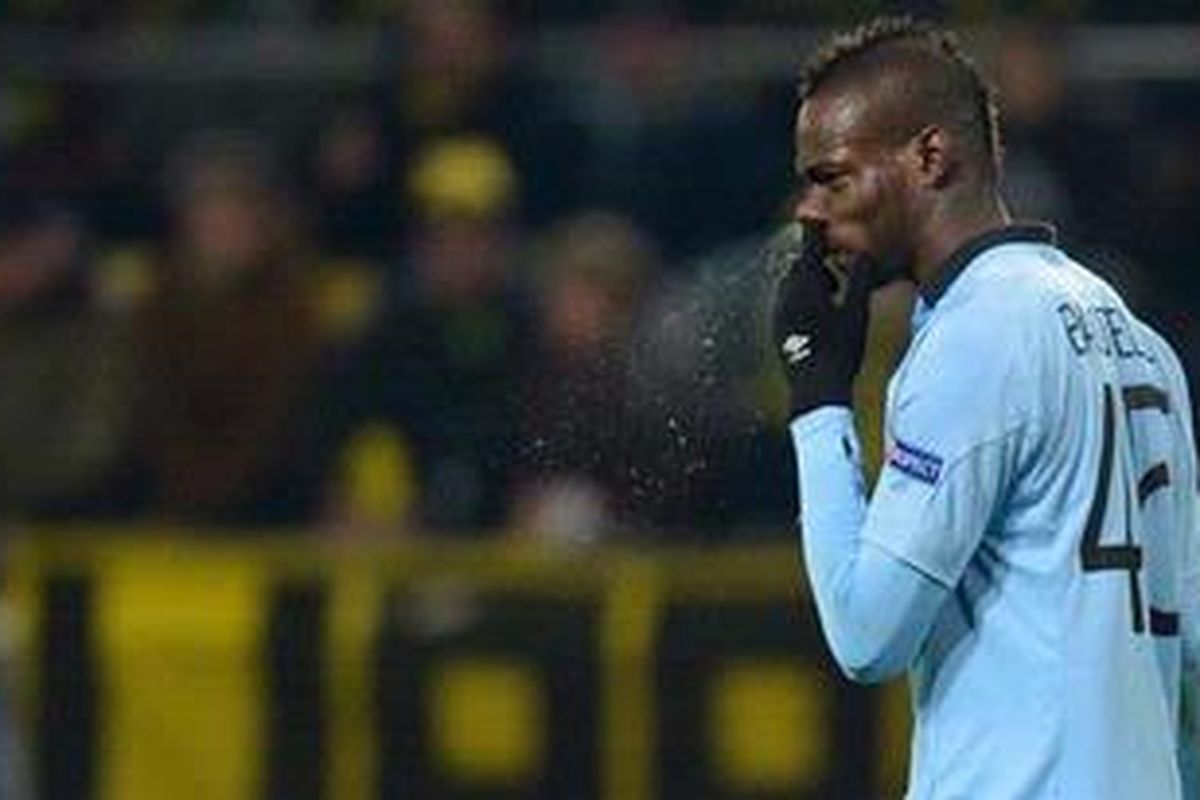 Striker Manchester City dari Italia, Mario Balotelli, membuang kotoran dari hidungnya dalam laga penyisihan Grup D Liga Champions melawan Borussia Dortmund pada 4 Desember 2012. 