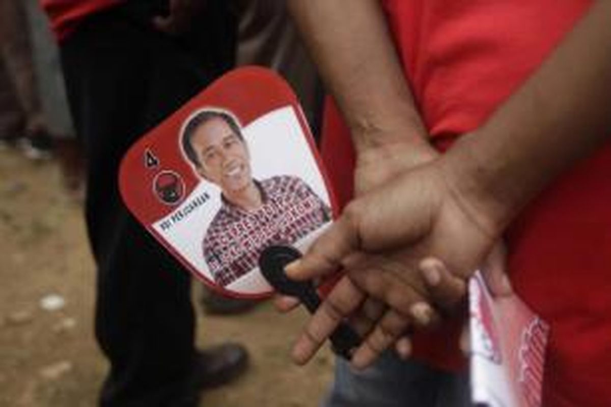 Simpatisan membawa kipas bergambar Joko Widodo atau Jokowi, saat calon presiden yang juga Gubernur DKI Jakarta tersebut menjadi juru kampanye PDI-P di lapangan Papua Trade Center, Jayapura, Papua, 5 April 2014. Jokowi juga menyempatkan diri untuk berkunjung ke pasar Yotefa di Abepura.