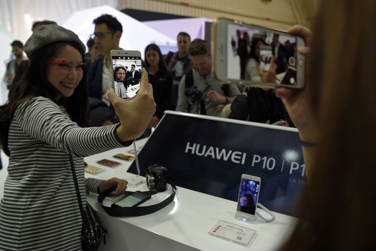 Wartawan menjajal model anyar besutan perusahaan telekomunikasi asal China, ponsel Huawei P10, pada malam menjelang pembukaan ajang Mobile World Congress di Barcelona, Spanyol, Minggu (26/2/2017).