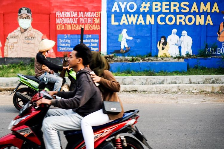 Pengendara melewati dinding yang dihiasi mural di Bukit Duri, Tebet, Jakarta pada Minggu (18/10/2020) sore.