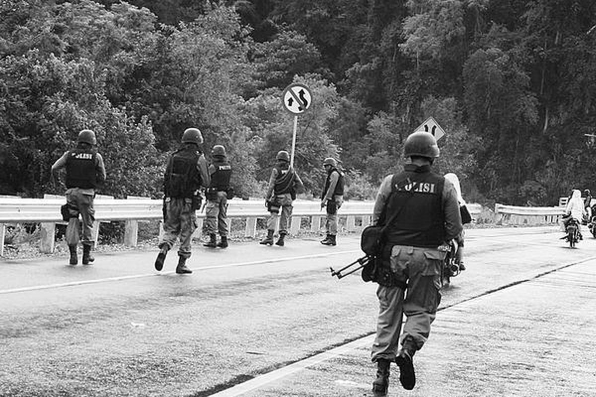 Sejumlah personel Detasemen Khusus 88 Antiteror bersiaga di Jalan Raya Banda Aceh-Meulaboh Kilometer 24 di Kecamatan Leupung, Kabupaten Aceh Besar, Provinsi Nanggroe Aceh Darussalam. Mereka mencari sisa-sisa teroris yang melarikan diri saat penyergapan.