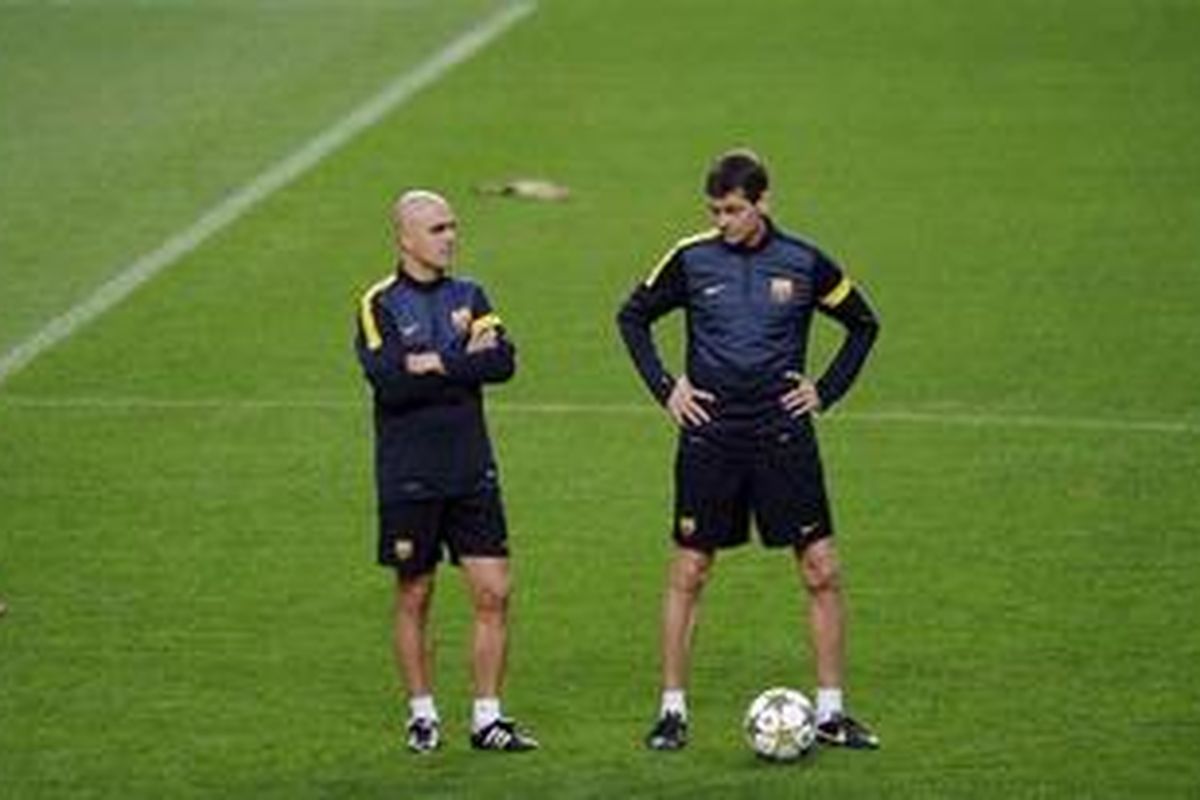 Pelatih Barcelona, Tito Vilanova (kanan), berbincang dengan terapis fisik timnya, Juano Brau, pada sesi latihan di Estadio Da Luz, Lisbon, Senin (1/10/2012). Latihan itu merupakan bagian persiapan Barcelona menghadapi Benfica, Selasa (2/10/2012). 