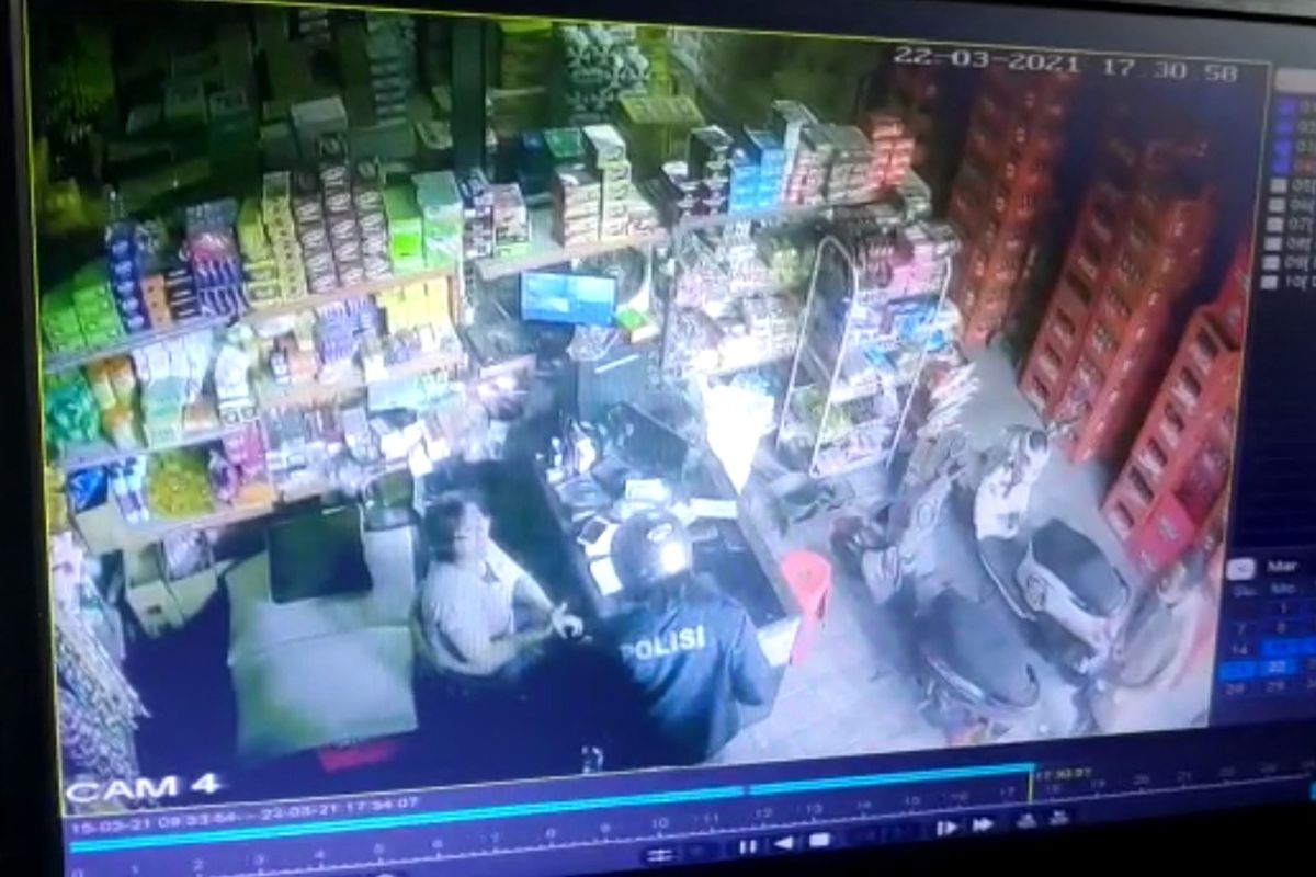 Tangkapan layar CCTV Sebuah aksi percobaan perampokan yang pelakunya mengenakan jaket bertuliskan polisi.