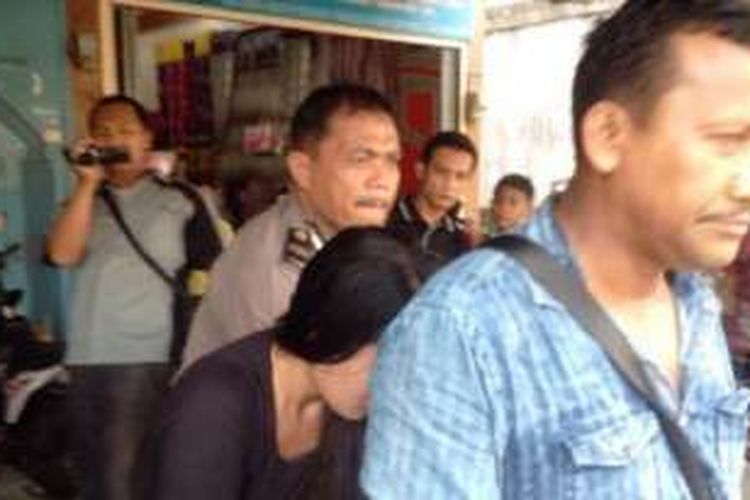 Polisi membawa perempuan yang digerebek bersama Mardiatoz Tanjung. 
