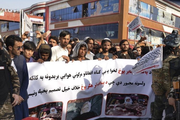 Demonstran memegang spanduk selama protes terhadap serangan udara Pakistan, di Khost pada 16 April 2022. 