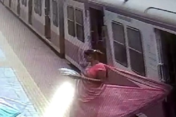 Foto yang diambil dari rekaman CCTV ini memperlihatkan detik-detik kain sari seorang perempuan terjepit pintu kereta api di sebuah stasiun di Maharashtra, India.