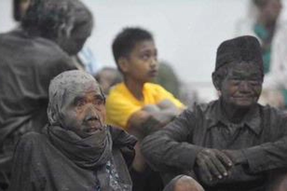 Warga dengan tubuh berlumur abu vulkanik mengungsi ke Stadion Maguwoharjo, Sleman, DI Yogyakarta, pascaerupsi Gunung Merapi, Jumat (5/11). Radius kawasan rawan bencana ditingkatkan dari 15 kilometer menjadi 20 kilometer pascaerupsi yang disertai luncuran awan panas dan mengakibatkan jatuhnya puluhan korban jiwa. 