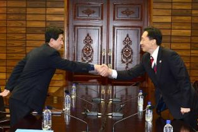 Dalam foto yang diambil pada 5 Februari 2014, Ketua delegasi Korea Selatan Lee Duk-haeng (kanan) menjabat tangan rekannya dari Korea Utara, Park Yong Il dalam pertemuan di desa perbatasan Panmunjom membahas soal reuni keluarga kedua negara.