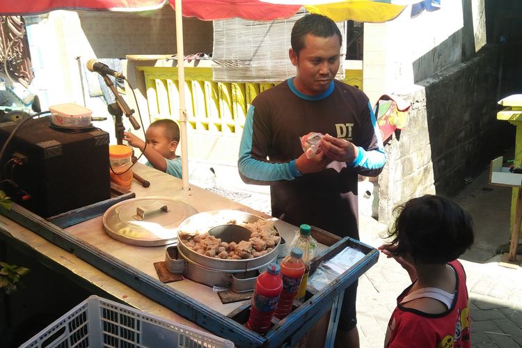 Soleh saat melayani para pembeli pentol buatannya yang dijual secara berkeliling.