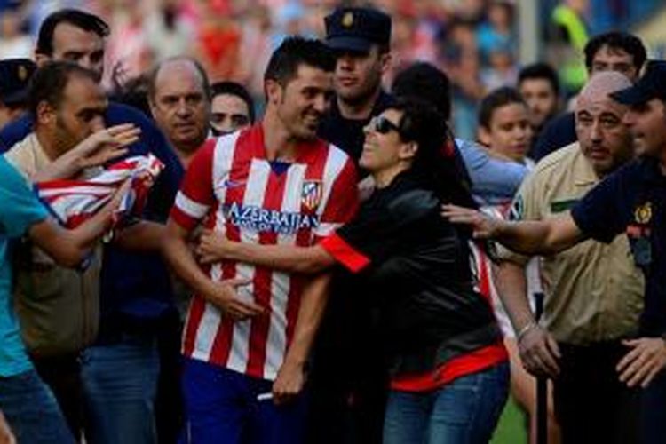 Striker David Villa (tenngah) dielu-elukan suporter Atletico Madrid.