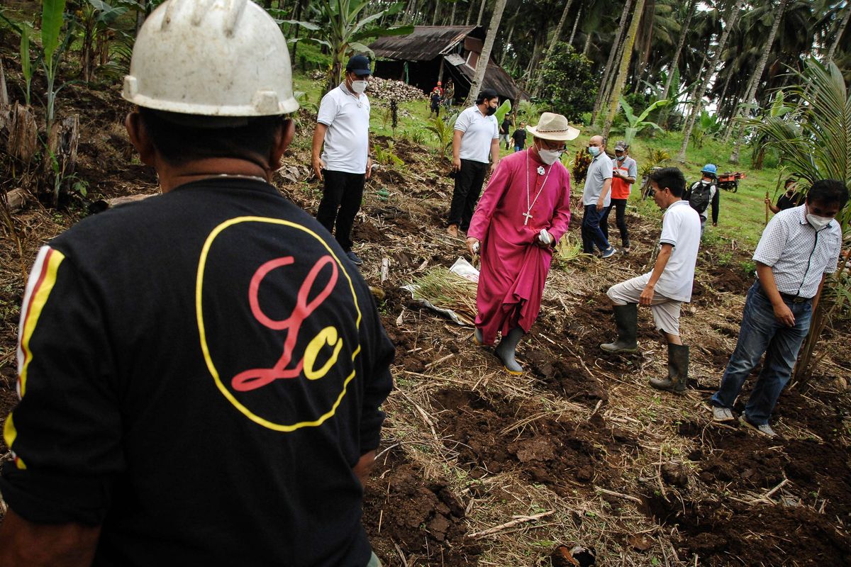 Foto dirilis Kamis (23/12/2021), memperlihatkan Uskup Keuskupan Manado, Mgr Benedictus Estephanus Rolly Untu bersama masyarakat menanam bibit serai wangi di lahan perkebunan Desa Lolah, Minahasa, Sulawesi Utara. Dalam mengembangkan ekosistem klaster serai wangi, Otoritas Jasa Keuangan (OJK) bersama stakeholder lainnya memberi dukungan melalui pengembangan penyaluran kredit usaha rakyat (KUR) berbasis klaster di berbagai daerah.