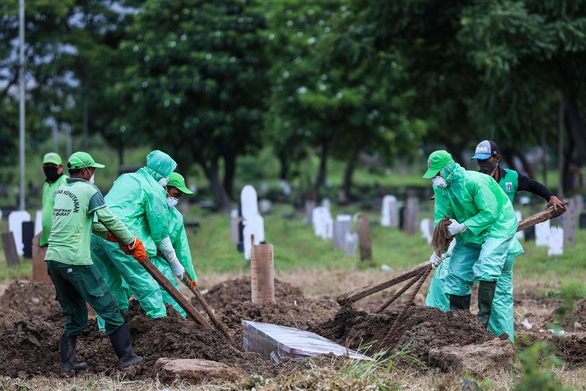 Petugas pemakaman membawa peti jenazah pasien suspect virus corona atau Covid-19 di TPU Tegal Alur, Jakarta Barat, Kamis (26/3/2020). Pemprov DKI Jakarta telah menyiapkan dua tempat pemakaman umum (TPU) untuk memakamkan pasien terjangkit virus corona (Covid-19) yang meninggal dunia, yakni di TPU Tegal Alur di Jakarta Barat dan TPU Pondok Ranggon di Jakarta Timur. Jenazah yang dapat dimakamkan di sana, yakni yang berstatus pasien dalam pengawasan (PDP) dan berstatus positif terjangkit virus corona.