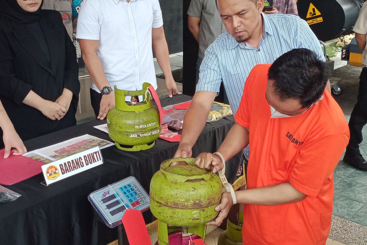 Tersangka Hendy saat mempraktikkan aksi pengoplosan elpiji subsidi ke nonsubsidi. 