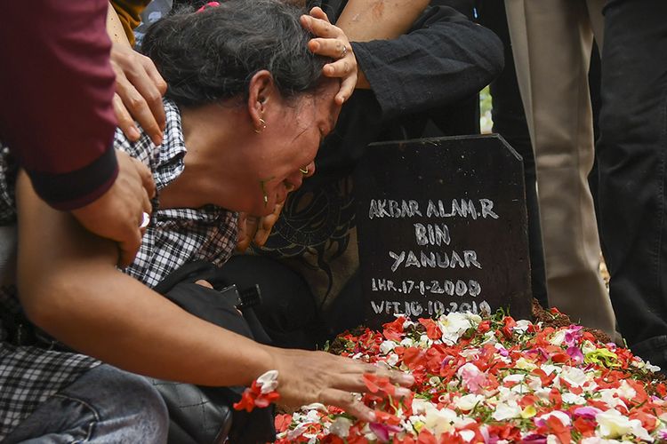 Ibu Akbar Alamsyah, Rosminah (kiri) menangis saat prosesi pemakaman korban demo ricuh Akbar Alamsyah di Taman Pemakaman Umum (TPU) kawasan Cipulir, Kebayoran Lama, Jakarta, Jumat (11/10/2019). Korban demo ricuh di DPR Akbar Alamsyah meninggal dunia di RSPAD Gatot Subroto, Kamis (10/10/2019) sekitar pukul 17.00 karena mengalami retak pada tempurung kepala.