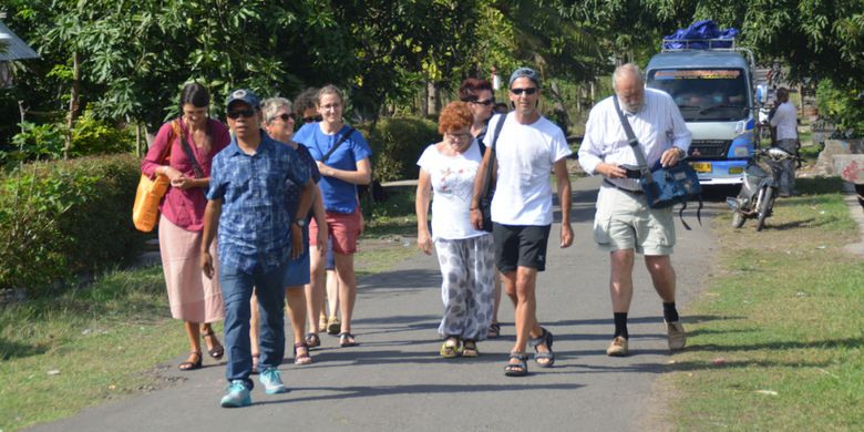 Turis Italia dan Jerman berjalan kaki menuju ke SMKP Waemokel, Kelurahan Watunggene, Kecamatan Kota Komba, Kabupaten Manggarai Timur, Flores, Nusa Tenggara Timur, Kamis (16/8/2018).