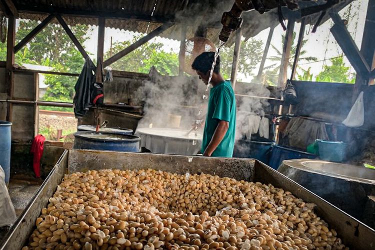 Perajin tahu tempe di Bandung Barat tengah meracik kacang kedelaindi rumah produksi tahu tempe, Selasa (11/10/2022).