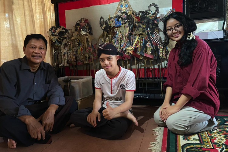 Dari kiri ke kanan: Ludy (ayah Rafa), Rafa, dan Azalea (penulis) dengan latar belakang koleksi wayang kulit milik Rafa.

