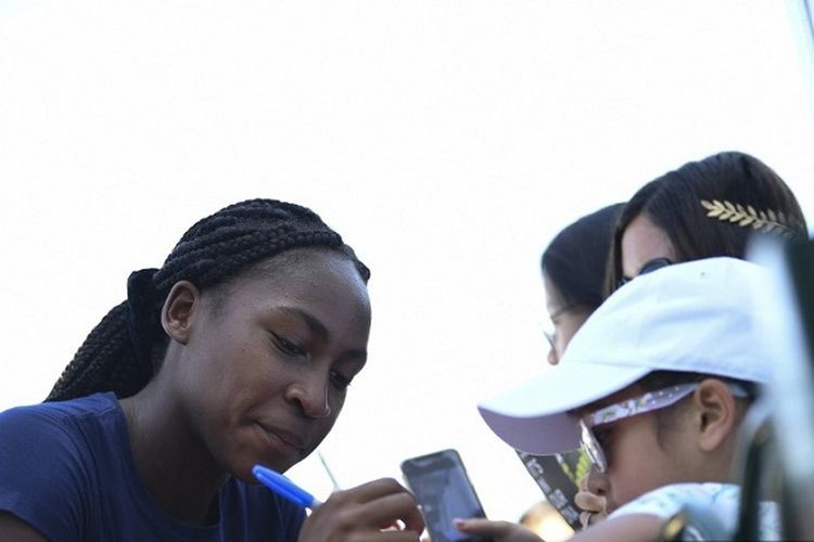 Petenis remaja AS berusia 15 tahun, Cori Gauff (kiri), memberi tanda tangan kepada penggemar setelah sesi latihan di The All England Tennis Club di Wimbledon, London, Inggris, pada 4 Juli 2019, pada hari keempat turnamen tenis Wimbledon 2019.