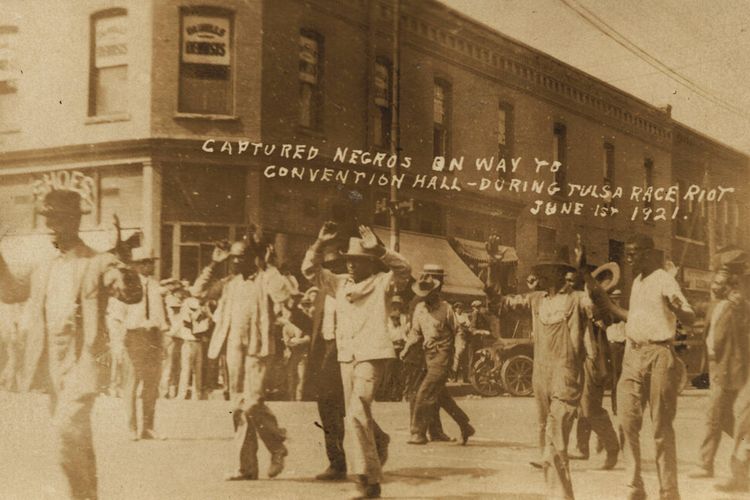 Dalam foto yang disediakan oleh Department of Special Collections, McFarlin Library, The University of Tulsa, sekelompok pria kulit hitam berbaris melewati sudut 2nd dan Main Streets di Tulsa, Okla., Di bawah penjagaan bersenjata selama Pembantaian Ras Tulsa pada bulan Juni. 1, 1921. 