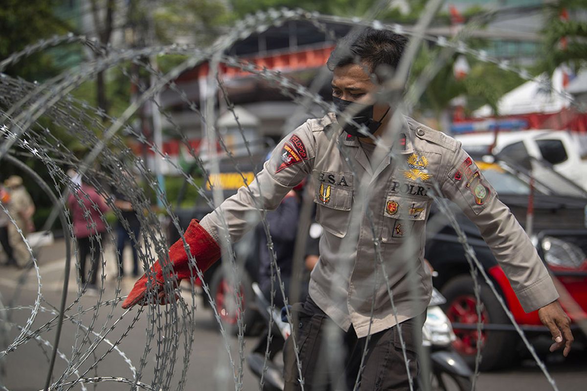 Polisi menata barikade kawat berduri dalam pengamanan sidang putusan banding Rizieq Shihab terkait perkara tes swab RS Ummi Bogor di Pengadilan Tinggi DKI Jakarta, Jakarta, Senin (30/8/2021). Majelis Pengadilan Tinggi DKI Jakarta menolak permohonan banding Rizieq Shihab dkk dan tetap dengan vonis empat tahun penjara.