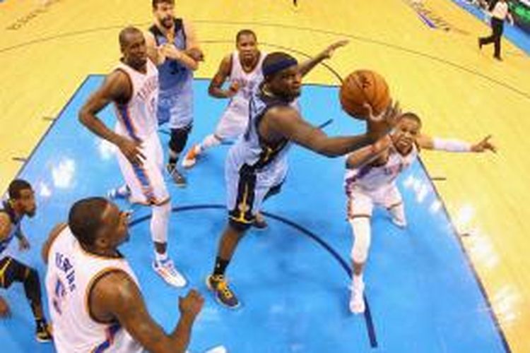 Pebasket Memphis Grizzlies Zach Randolph mencoba memasukkan bola di antara kepungan para pemain Oklahoma City Thunder pada lanjutan babak play-off Wilayah Barat, Seni (21/4/2014).