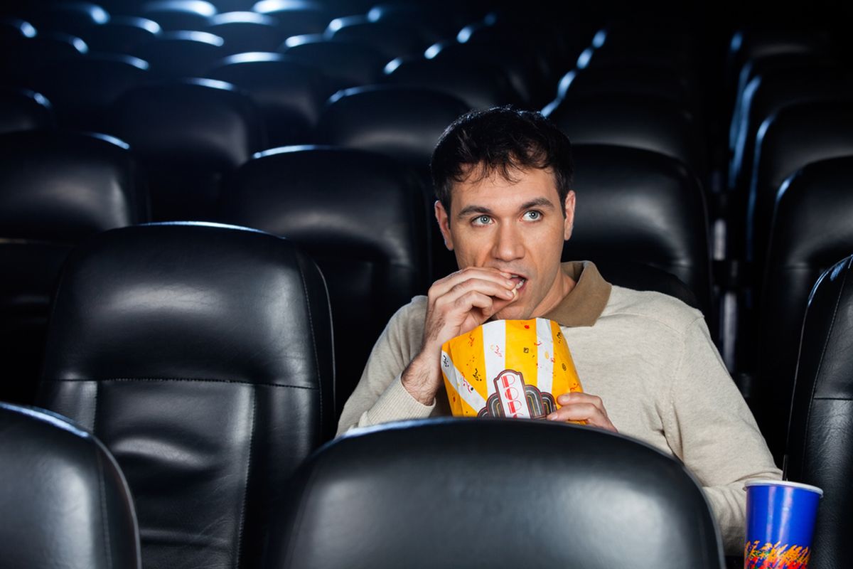 Ilustrasi orang makan di bioskop. 