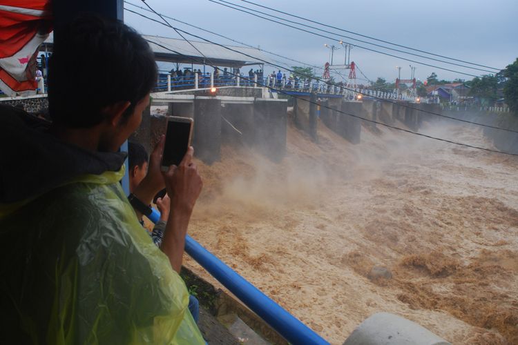 Warga berdatangan ke Bendungan Katulampa, Bogor, Senin (5/2/2018). Mereka penasaran dengan kondisi air. Sejak pagi, ketinggian muka air di bendungan ini sudah mencapai 220 sentimeter dan berstatus Siaga 1.