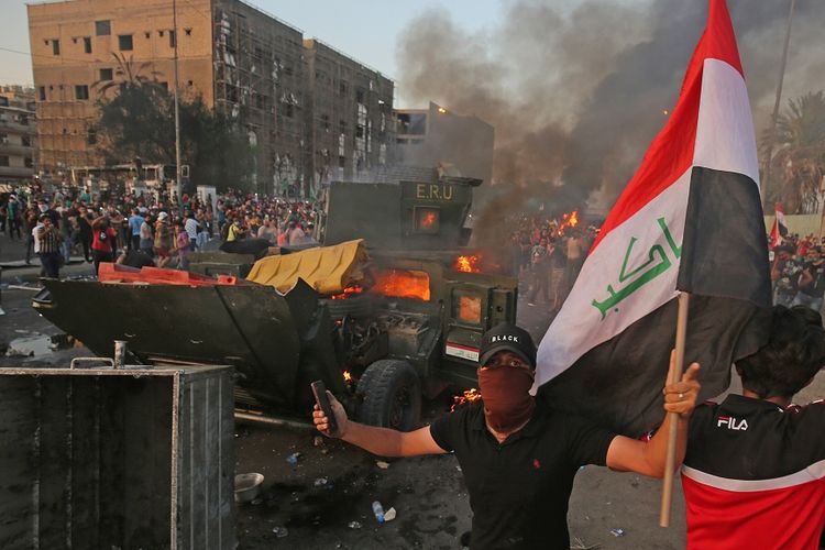 Massa demonstrasi membawa bendera Irak dalam aksi di Baghdad, Kamis (3/10/2019).