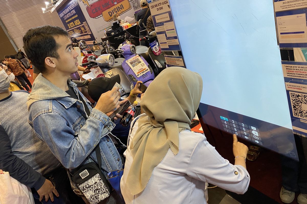 Pengunjung Jakarta Fair 2023 melakukan cek penerima Subsidi Motor Listrik