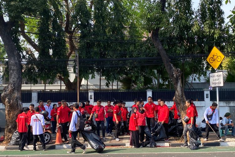 Relawan Ganjar-Mahfud membantu membersihkan sampah di area Komisi Pemilihan Umum (KPU) RI, Menteng, Jakarta Pusat, Kamis (19/10/2023).