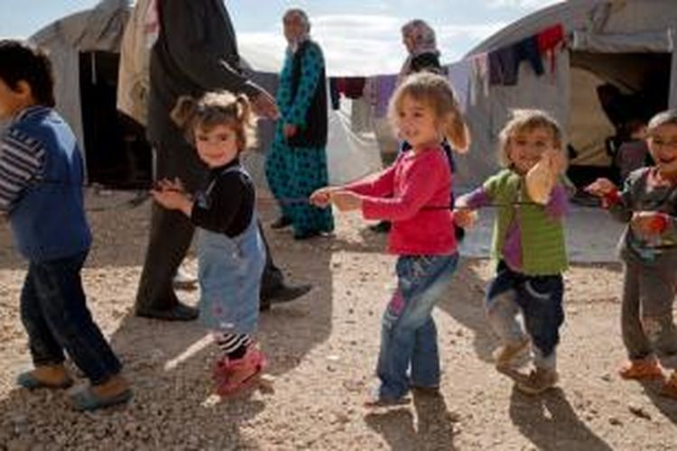 Anak-anak Kurdi Suriah sedang bermain di kamp pengungsian di Turki setelah keluarga mereka kabur meninggalkan kota Kobani yang sejak enam pekan lalu diserang pasukan Negara Islam Irak dan Suriah (ISIS).