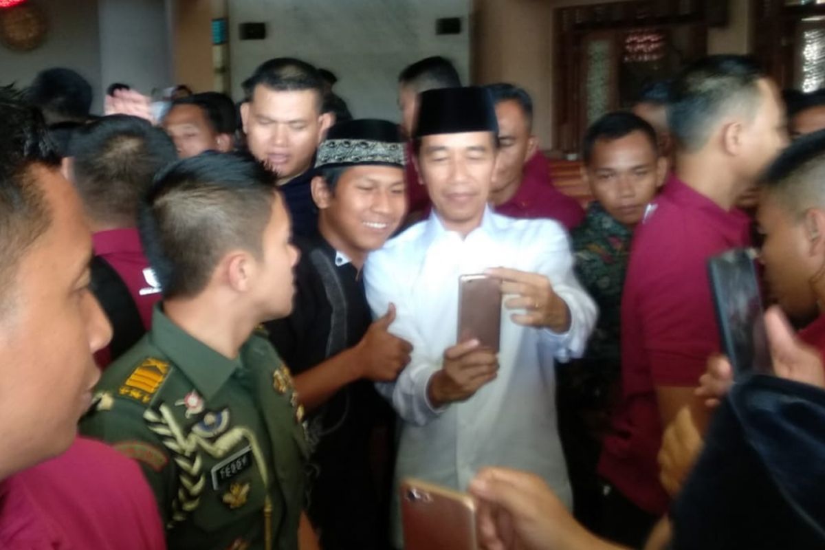 Presiden Jokowi Selfie dengan warga seusai bagikan 351 sertifikat tanah wakaf di Tangerang Selatan, Jumat ( 22/2/2019) .