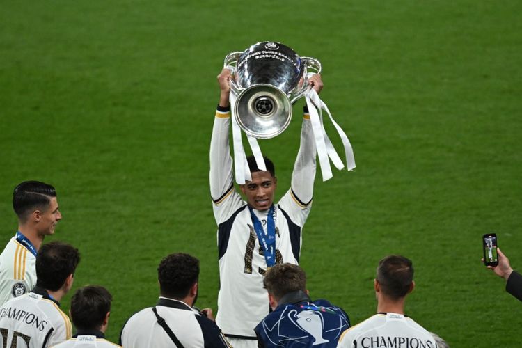 Jude Bellingham mengangkat trofi Liga Champions. Real Madrid menjadi juara Liga Champions setelah menang 2-0 atas Borussia Dortmund di Stadion Wembley, London, Inggris, Minggu (2/6/2024) dini hari WIB. (Photo by JUSTIN TALLIS / AFP)