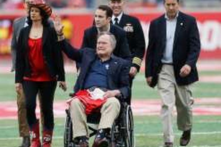 Mantan Presiden AS, George HW Bush, melambaikan tangan kepada kerumunan massa di Stadion TEDECU, November  2015 di Houston, Texas. 
