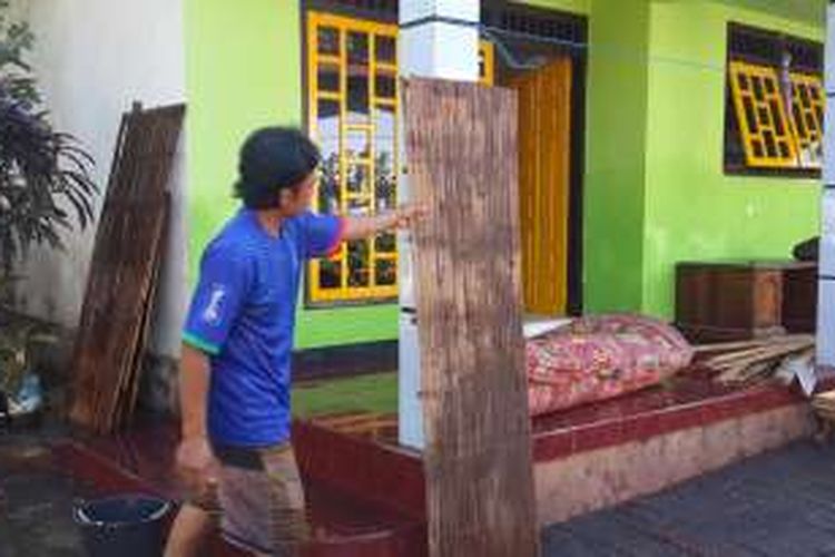 Seorang warga terdampak banjir di Kabupaten Pasuruan, Jawa Timur saat membersihkan seisi rumahnya, Jumat (1/7/2016)