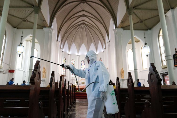 Petugas membersihkan dan menyemprotkan disinfektan di Gereja Katedral Bogor usai digunakan ibadah, Minggu (12/7/2020). Mulai Sabtu (11/7/2020), Gereja Katedral Bogor mulai menggelar misa percobaan di masa transisi kenormalan baru dengan menerapkan berbagai protokol kesehatan antara lain mewajibkan penggunaan masker, hand sanitizer, serta membatasi kuota jumlah umat yang datang ke gereja sebanyak 200 orang setiap misa.