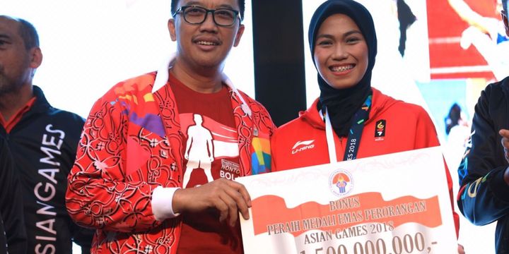 Menpora Imam Nahrawi menyerahkan secara simbolis bonus kepada atlet peraih medali emas Asian Games 2018, Defia Rosmaniar, di Kemenpora, 20 Agustus 2018. 