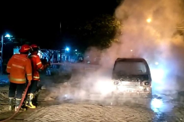 Petugas saat memadamkan api yang membakar mobil carry milik Muhammad Kojin di Desa Banjaran, Kecamatan Driyorejo, Gresik, Minggu (5/6/2022) malam.