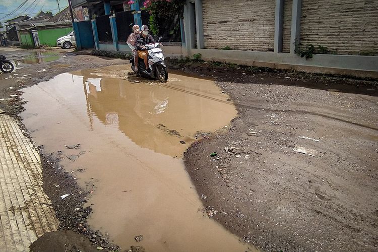 Genangan air di jalan berlubang di Jalan Cisarongge, Desa Mekarmukti, Kecamatan Cihampelas,Bandung Barat, Kamis (18/1/2023).